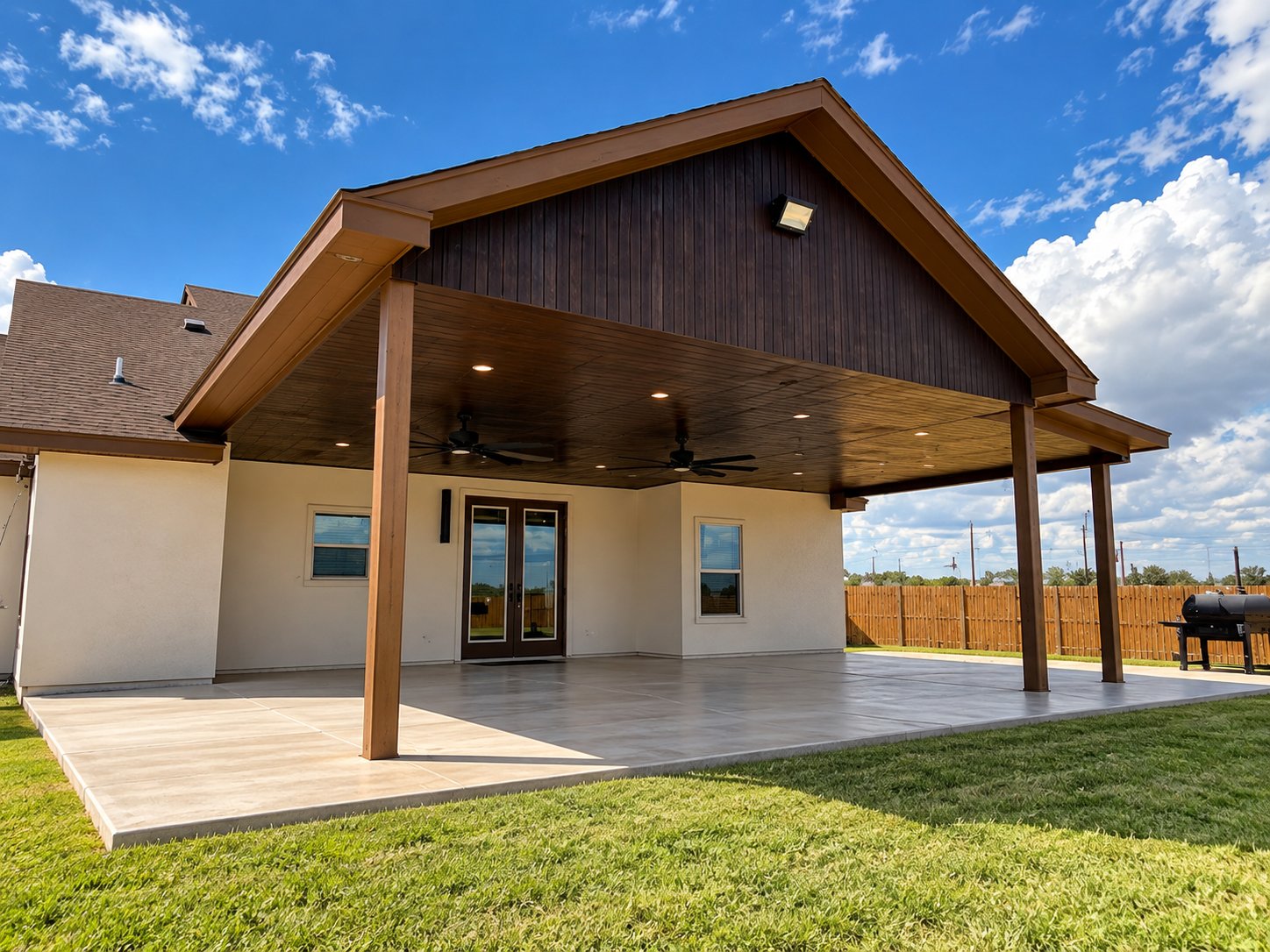 Covered backyard patio pavilion with wood ceiling, recessed lights and concrete slab